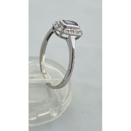 192 - A 9ct white gold dress ring, set with an emerald cut tanzanite to the centre, with small diamonds su... 