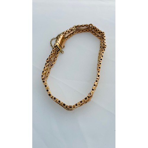 196 - A 15ct yellow gold gate bracelet, with safety chain, weighing 11.8 grams.