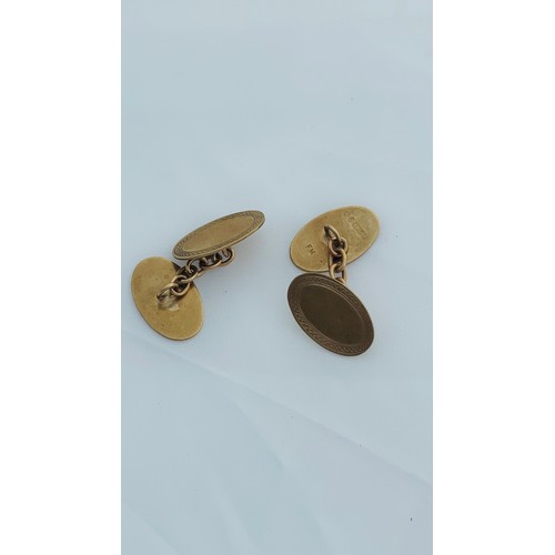 199 - A pair of 9ct gold oval shaped cufflinks with chains, weighing 5.2 grams.