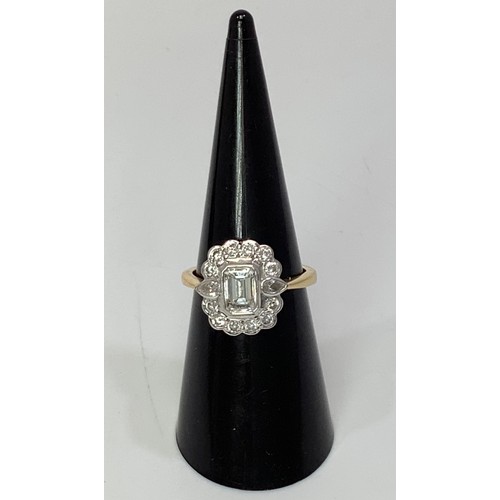 234 - An 18ct yellow gold and diamond cluster ring, centrally bezel set an emerald-cut diamond, extimated ... 