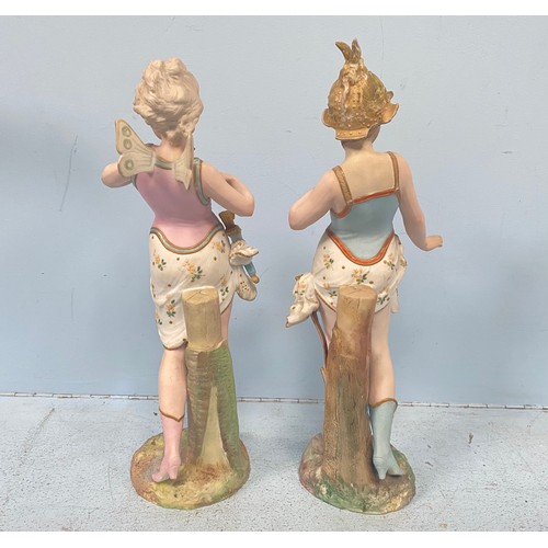 61 - A pair of bisque porcelain figures of fairies leaning against tree stumps, raised on naturalistic ba... 