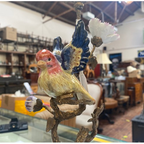 461 - A pair of bronze figural candlesticks by Mark Roberts, with colourful porcelain birds perched on twi... 