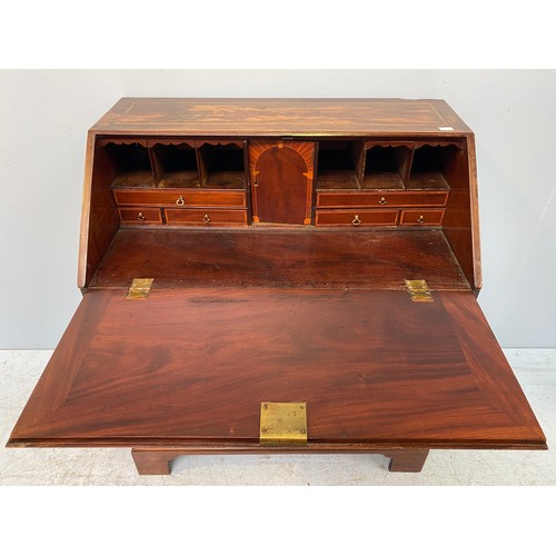 277 - A George III mahogany and veneered bureau with sloped front above four long graduated drawers, raise... 