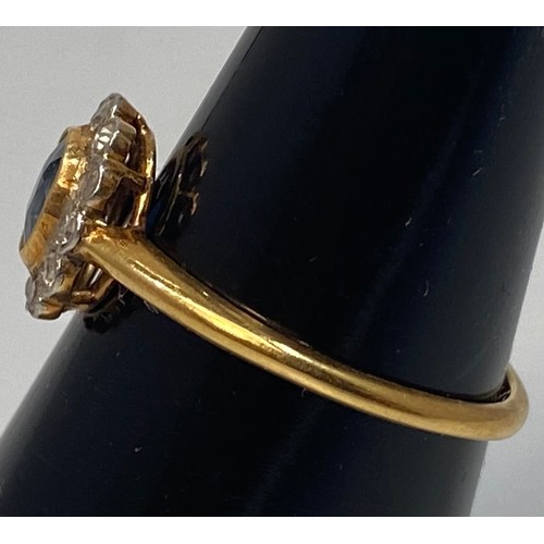 120 - An 18ct gold ring, centrally set with an oval faceted sapphire stone, surrounded by 12x small eight-... 