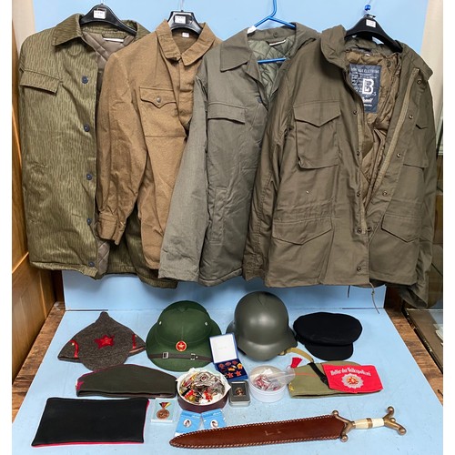 393 - A quantity of replica military jackets, helmet, Russian cap, Vietnamese helmet, communist and German... 