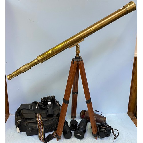 214 - A floor standing brass telescope with wooden tripod stand, together with a quantity of camera equipm... 