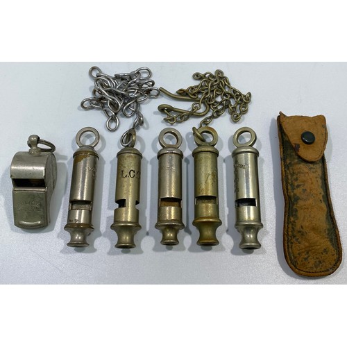 556 - Six various whistles including LCC, a 1915 dated example with chain and button hook, ACME Metropolit... 