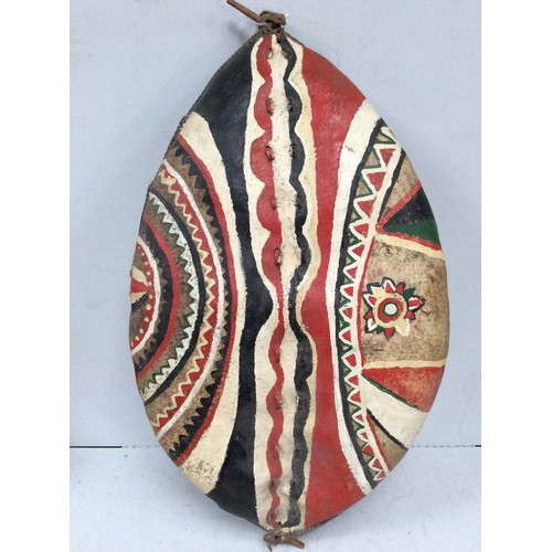 414 - A mid 20th century Maasai shield, Kenya hide and painted with red, white, black and green geometric ... 