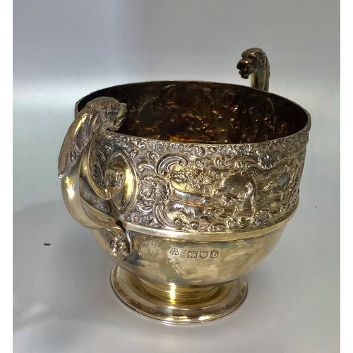 45 - A silver twin-handled cup, the top half decorated in relief with a continuous hunting scene, hallmar... 