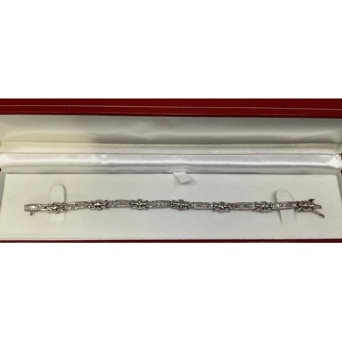 115 - A 14ct white gold and diamond tennis bracelet, set with multiple baguette and tapered baguette diamo... 