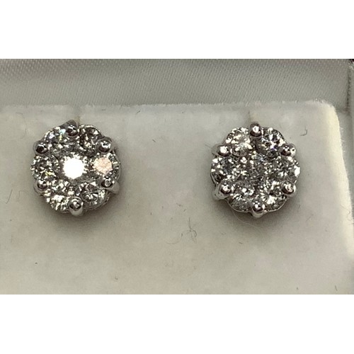 116 - A pair of 14ct white gold and diamond cluster stud earrings, each set with seven round brilliant cut... 