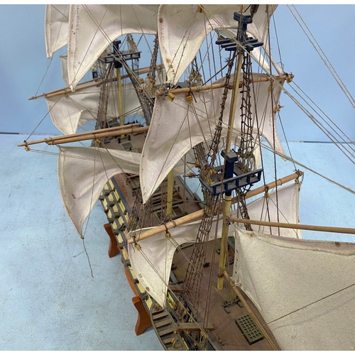 571 - A large hand built model of HMS Victory fully rigged with Nelson standing on the bow, raised on wood... 