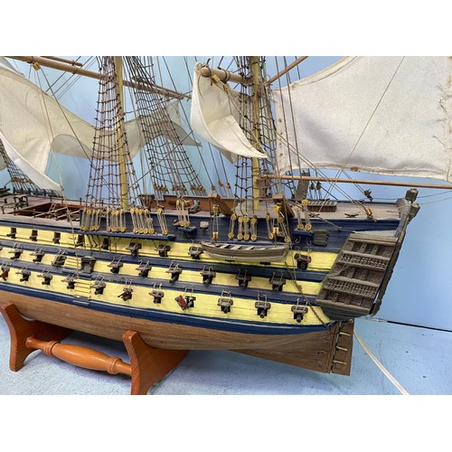 571 - A large hand built model of HMS Victory fully rigged with Nelson standing on the bow, raised on wood... 