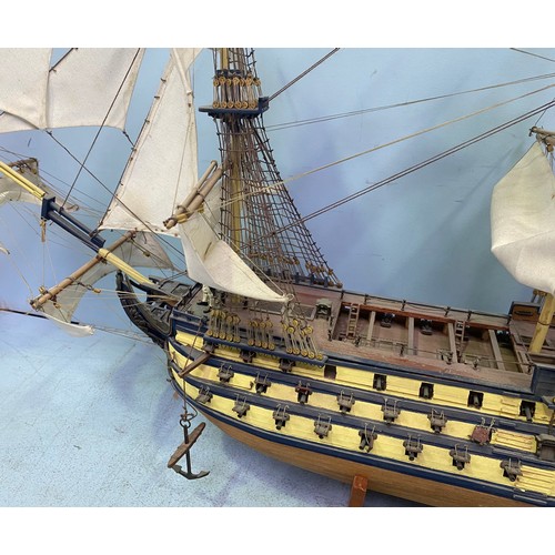 571 - A large hand built model of HMS Victory fully rigged with Nelson standing on the bow, raised on wood... 