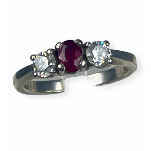 124 - A platinum ring set with a central oval ruby and two round brilliant cut diamonds, all in claw setti... 