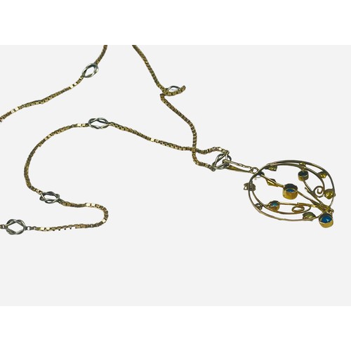 126 - A circular yellow metal pendant, set with blue stones and seed pearls, suspended on a 9ct yellow and... 