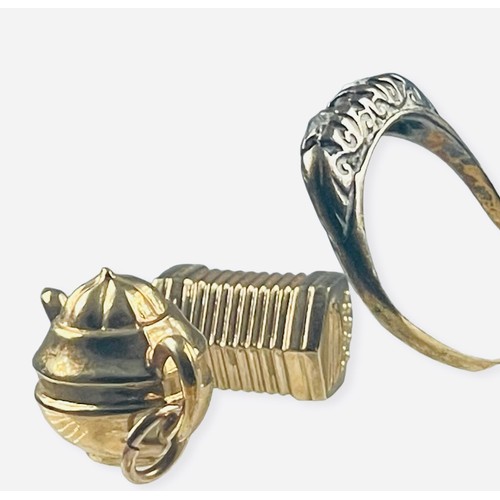 128 - Two 9ct gold charms, one designed as a teapot, the other an accordion, together with an 18ct gold ri... 