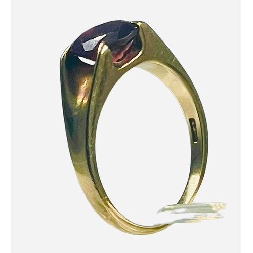 134 - A 9ct yellow gold dress ring, set with a round faceted garnet, ring weighs 3.7 grams, finger size Q