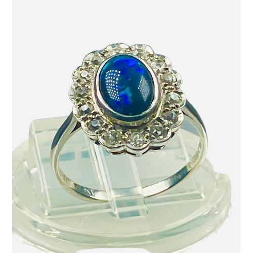 82 - A platinum dress ring, set with an oval shaped dark blue opal to the centre, measuring approximately... 