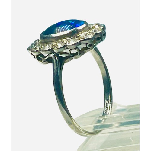 82 - A platinum dress ring, set with an oval shaped dark blue opal to the centre, measuring approximately... 