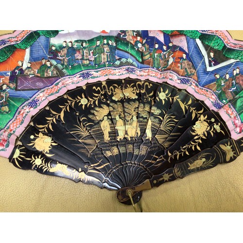 204 - A late 19th/early 20th century Chinese lacquered fan, the sticks with gilt scenes of figures convers... 