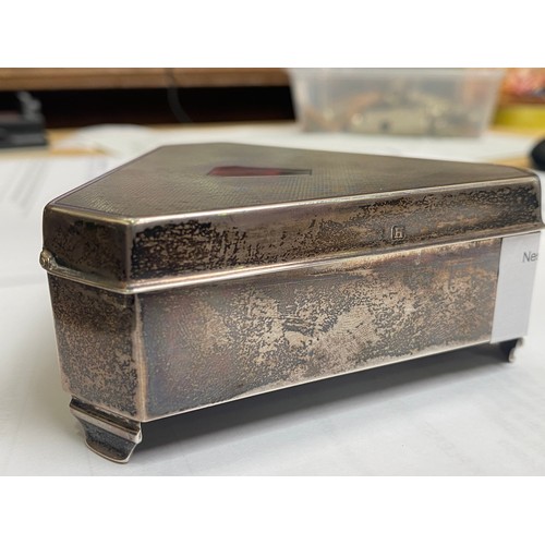 53 - A silver casket of triform with canted corners, engine-turned hinged cover enclosing gold satin inte... 