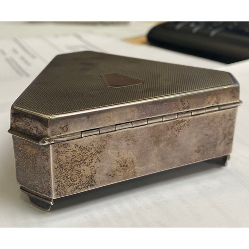 53 - A silver casket of triform with canted corners, engine-turned hinged cover enclosing gold satin inte... 