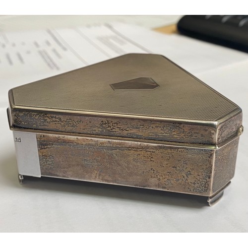 53 - A silver casket of triform with canted corners, engine-turned hinged cover enclosing gold satin inte... 