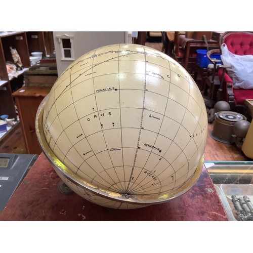 373 - A Hezzanith star globe in cream enamel with the tropical zodiac outlined in black, hung on gilt ring... 