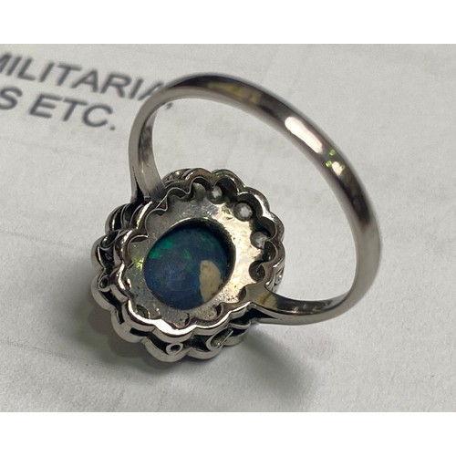 82 - A platinum dress ring, set with an oval shaped dark blue opal to the centre, measuring approximately... 