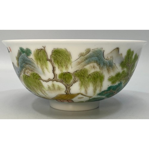 38 - A Chinese porcelain bowl hand painted with a scene of a figure of a man on a raft with houses, trees... 