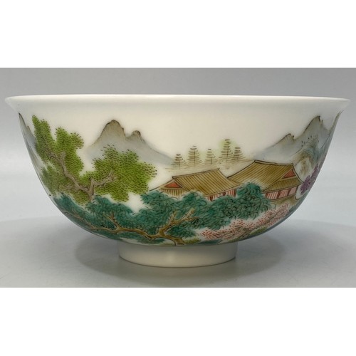 38 - A Chinese porcelain bowl hand painted with a scene of a figure of a man on a raft with houses, trees... 