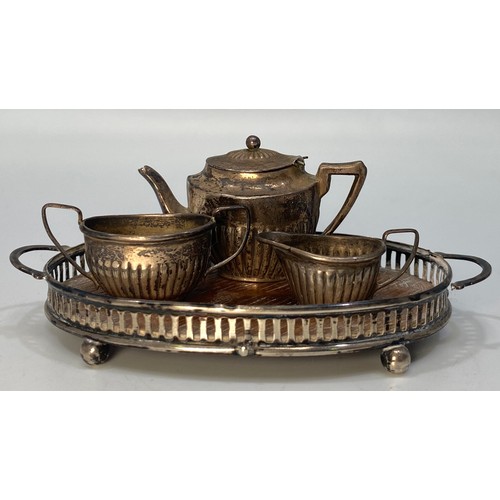 176 - An Edwardian Four-Piece Miniature teaset, comprising teapot, sugar and cream jug on oval pierced gal... 