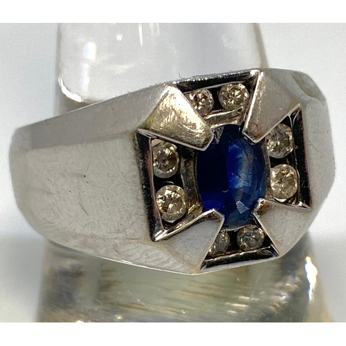 356 - A gents 10ct white gold ring set with central oval faceted sapphire coloured stone, flanked by a pai... 