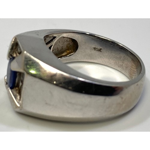 356 - A gents 10ct white gold ring set with central oval faceted sapphire coloured stone, flanked by a pai... 