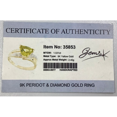 293 - A 9ct gold Peridot and diamond ring, centrally three-claw-set with a trilliant cut peridot, flanked ... 