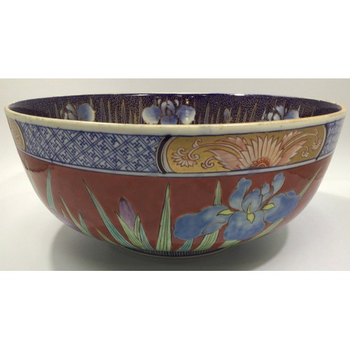 52 - A large Oriental pottery bowl, decorated in polychrome enamels with floral designs, 31cm diameter