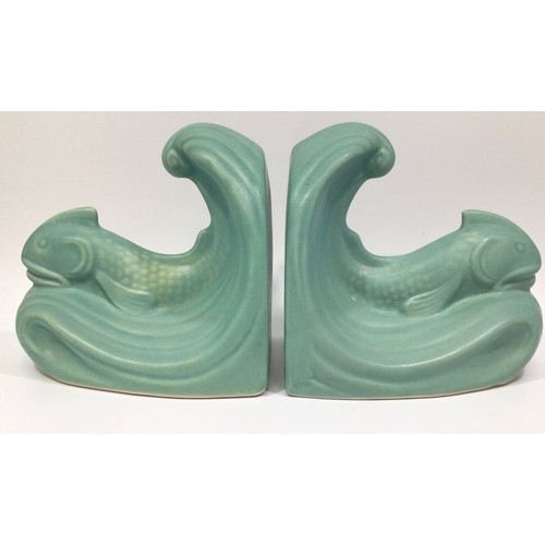 113 - A pair of green-glazed Langley Pottery bookends modelled as dolphins on wave crests, designed by Fra... 