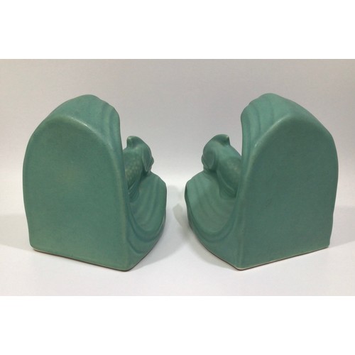 113 - A pair of green-glazed Langley Pottery bookends modelled as dolphins on wave crests, designed by Fra... 