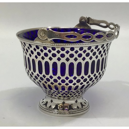 167 - A silver sugar basket by Barker Brothers, the entirety with pierced decoration and hinged handle, wi... 