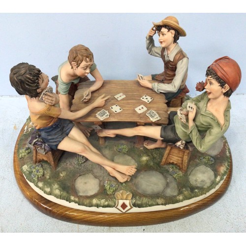 20 - A Capodimonte figural group 'The Cheats' depicting four young boys playing cards on raised wooden pl... 