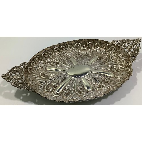 196 - A late Victorian heavily embossed oval dish with floral and figural pierced pointed handles, London,... 