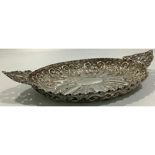 196 - A late Victorian heavily embossed oval dish with floral and figural pierced pointed handles, London,... 