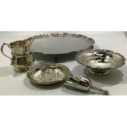 197 - A silver cream jug together with a silver pin dish with shaped rim, a silver pin dish with floral ca... 