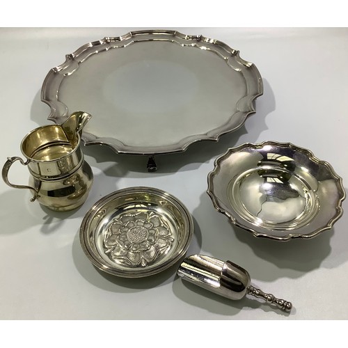 197 - A silver cream jug together with a silver pin dish with shaped rim, a silver pin dish with floral ca... 