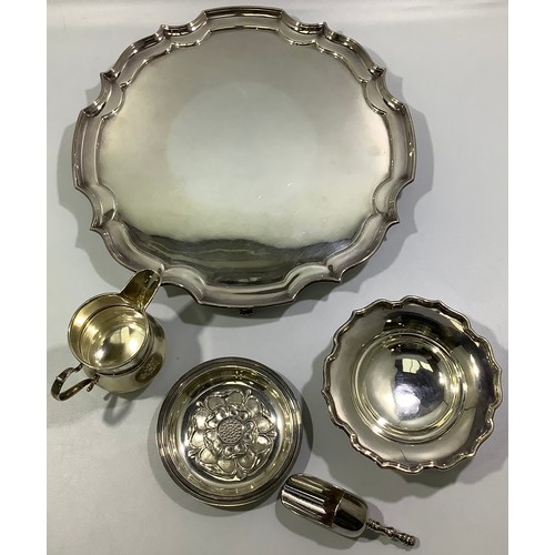 197 - A silver cream jug together with a silver pin dish with shaped rim, a silver pin dish with floral ca... 