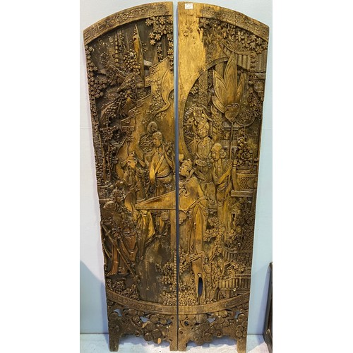 641 - A pair of carved Chinese hardwood panels, formerly from a dressing screen, carved with figures amids... 