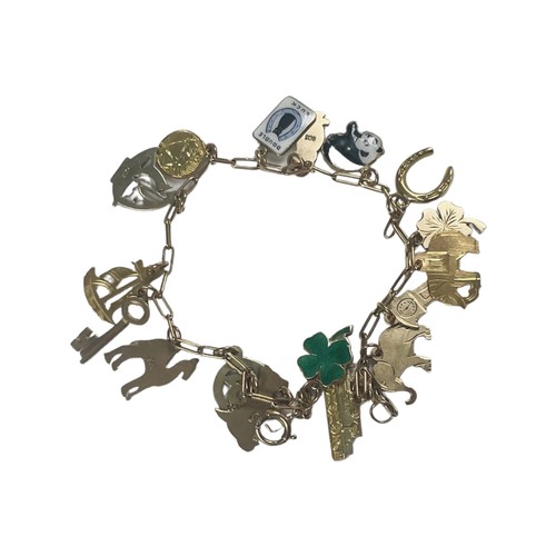 307 - A 9ct yellow gold charm bracelet, with 17 x charms, including a four leaf clover, a key, a St Christ... 