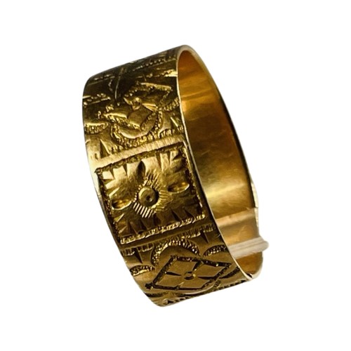 323 - An 18ct gold wide engraved wedding band, ring size M, (af) weighs 3.4 grams.