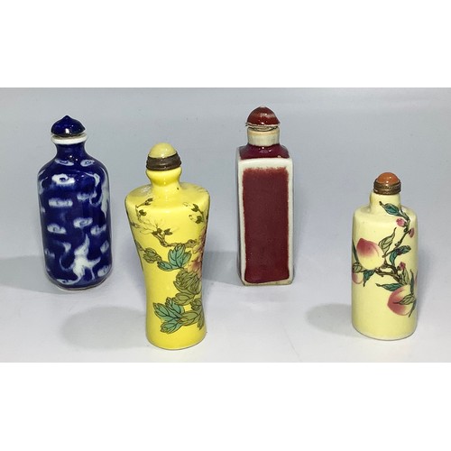 47 - Four various Chinese snuff bottles including a yellow example with flowers, a blue and white example... 